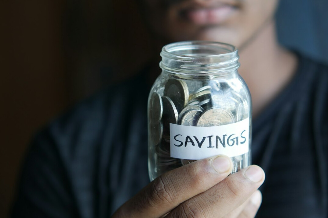 person saving coins in jar